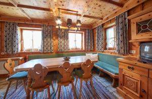 comedor con mesa, sillas y TV en FIVE SEASONS - Hideaway Saalbach, en Saalbach Hinterglemm