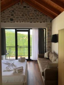 a living room with a bed and a couch at Bujtina Vrenezi in Peshkopi