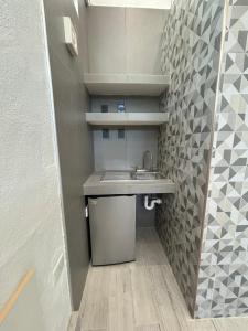 baño pequeño con lavabo y pared de azulejos en Rose 5 en Cancún