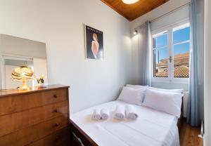 una camera da letto con un letto con lenzuola bianche e una finestra di Lefkada white house a Città di Lefkada
