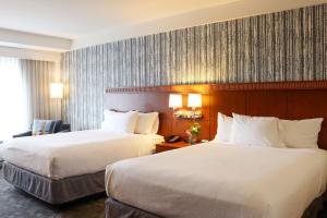 a hotel room with two beds and a window at The Harborvale, Autograph Collection in Burlington +10 photos