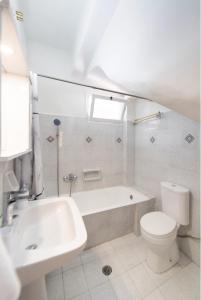y baño con bañera, aseo y lavamanos. en Lefkada white house, en Lefkada