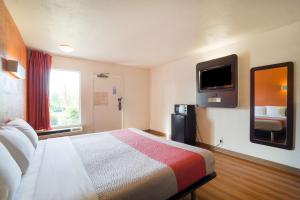 a hotel room with a bed and a tv on the wall at Motel 6 - Augusta, GA in Augusta
