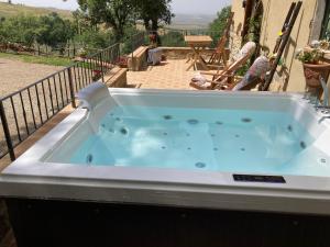 una gran bañera de hidromasaje en un balcón en Val D’Orcia Eco Cottage, en Campiglia dʼOrcia