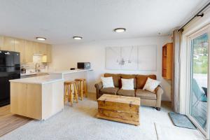 uma cozinha e sala de estar com um sofá e uma mesa em Slope-Walk Condo em Sandpoint