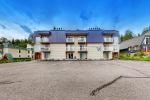 a large apartment building with a large parking lot at Slope-Walk Condo in Sandpoint