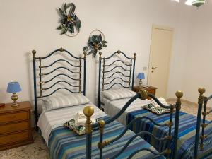 sypialnia z 2 łóżkami z niebiesko-białą prześcieradłem w obiekcie interno13bari w mieście Bari
