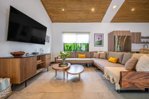 a living room with a couch and a tv at Casa de Armonia in Tamarindo