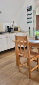 uma cozinha com uma mesa de madeira e uma cadeira de madeira em Kwatery Prywatne Beata em Darłowo