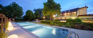 a swimming pool in front of a building at Garden & SPA Hotel Das Götzfried in Regensburg
