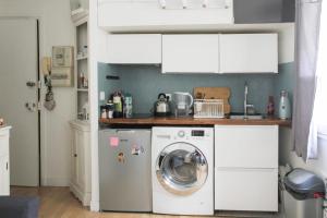 a kitchen with a washing machine in a kitchen at A cosy little nest in the 5th arrondissement in Paris