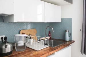 a kitchen counter with a sink and a dish rack at A cosy little nest in the 5th arrondissement in Paris