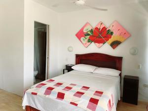 1 dormitorio con 1 cama y pinturas en la pared en Bahia B&B, en Bahía de Caráquez