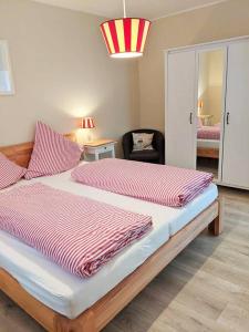 - une chambre dotée d'un grand lit avec des draps rouges rayés dans l'établissement Ferienwohnung Anna, à Winterberg