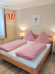 - une chambre avec 2 lits avec des draps rayés roses dans l'établissement Ferienwohnung Anna, à Winterberg