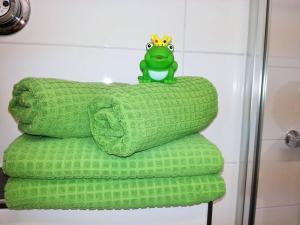 une pile de serviettes vertes avec une grenouille assise sur elles dans l'établissement Ferienwohnung Anna, à Winterberg