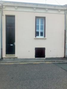 ein weißes Gebäude mit einer Tür und einem Fenster in der Unterkunft Bordeaux Rive Droite in Cenon