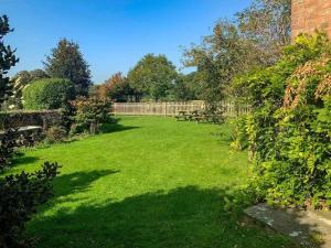 a large yard with benches and a fence at Cosy Farm house in Forest of Dean in Westbury on Severn