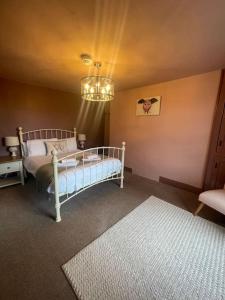 a bedroom with a bed and a chandelier at Cosy Farm house in Forest of Dean in Westbury on Severn