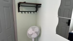 Camera bianca con ventilatore e specchio. di Homestay in Walsall a Walsall