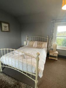 sypialnia z białym łóżkiem i oknem w obiekcie Cosy Farm house in Forest of Dean w mieście Westbury on Severn