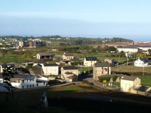 Une petite ville avec des maisons et l'océan dans l'établissement Hotel Restaurante Las Camelias, à Jarrio