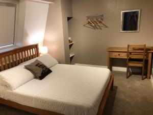 a bedroom with a bed and a desk and a chair at The Old Post Office House BnB in Balmacara