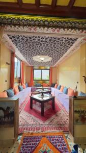 una sala de estar con sofás blancos y una mesa. en Riad Atlas Imlil, en Imlil