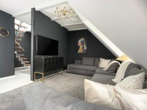 uma sala de estar com um sofá e uma televisão em M-Style 04 Apartment mit Balkon und Gasgrill, 24h Self-Check-In, Free Parking, Netflix em Nurembergue