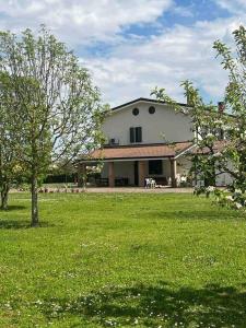 a large house with a green yard with a tree at Villa Rita - Rooms&Art in Case Ghisiolo