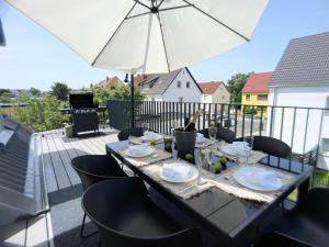 a table on a balcony with an umbrella at M-Style 04 Apartment mit Balkon und Gasgrill, 24h Self-Check-In, Free Parking, Netflix in Nürnberg