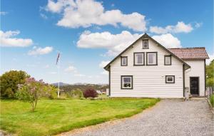 ein weißes Haus mit einer Flagge im Hof in der Unterkunft Beautiful Home In Sveio With Wifi in Kvalvåg