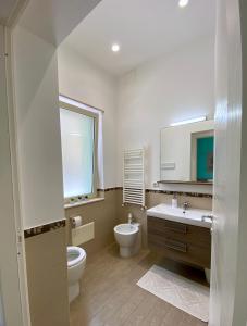 a bathroom with a toilet and a sink and a mirror at AL 136 in Capo dʼOrlando +22 photos
