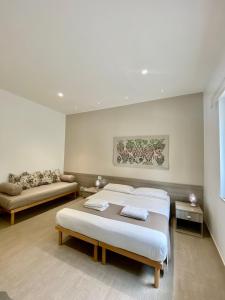 a bedroom with two beds and a couch at AL 136 in Capo dʼOrlando