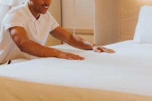 a man working on a bed in a room at Grand Tonic Hotel & SPA NUXE in Biarritz