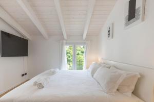 a white bedroom with a large bed and a window at Olmo Suites in Como