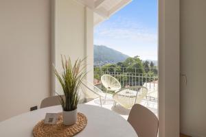 a white dining room with a table and a balcony at Olmo Suites in Como