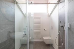 een badkamer met een douche, een toilet en een wastafel bij Olmo Suites in Como