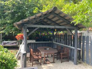 a wooden gazebo with a table and chairs at Pentz House in Siófok