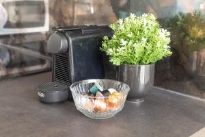 a coffee maker and a bowl with candles and a plant at Olmo Suites in Como