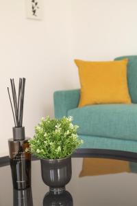a table with two vases with flowers and a couch at Olmo Suites in Como