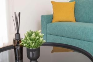 a green chair with a yellow pillow and a vase with flowers at Olmo Suites in Como