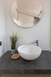 a bathroom with a large white bowl on a counter with a mirror at Olmo Suites in Como