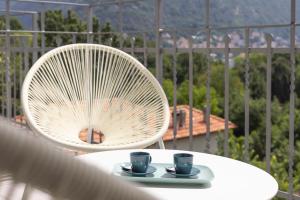 a white table with two cups and a chair at Olmo Suites in Como