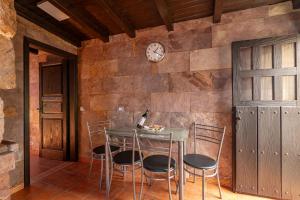 a table with chairs and a clock on a wall at Casa Los Pinos in Mogán