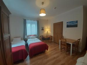 1 Schlafzimmer mit 2 Betten, einem Tisch und einem Schreibtisch in der Unterkunft To Tutaj in Szklarska Poręba