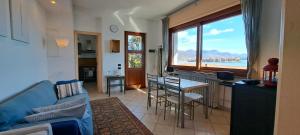 a living room with a couch and a kitchen with a large window at Villa la Serra in Baveno
