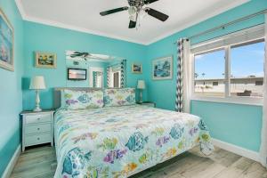 Schlafzimmer mit einem Bett mit blauen Wänden und einem Fenster in der Unterkunft Five Palms Vacation Rentals- Daily - Weekly - Monthly in Clearwater Beach