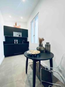 ein Zimmer mit einem Tisch und einem Stuhl in einem Zimmer in der Unterkunft La Litchi Le 50 Suites and Spa centre ville in Bordeaux