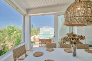 a dining room with a table and a view of the ocean at Villa Yialos in Antiparos Town